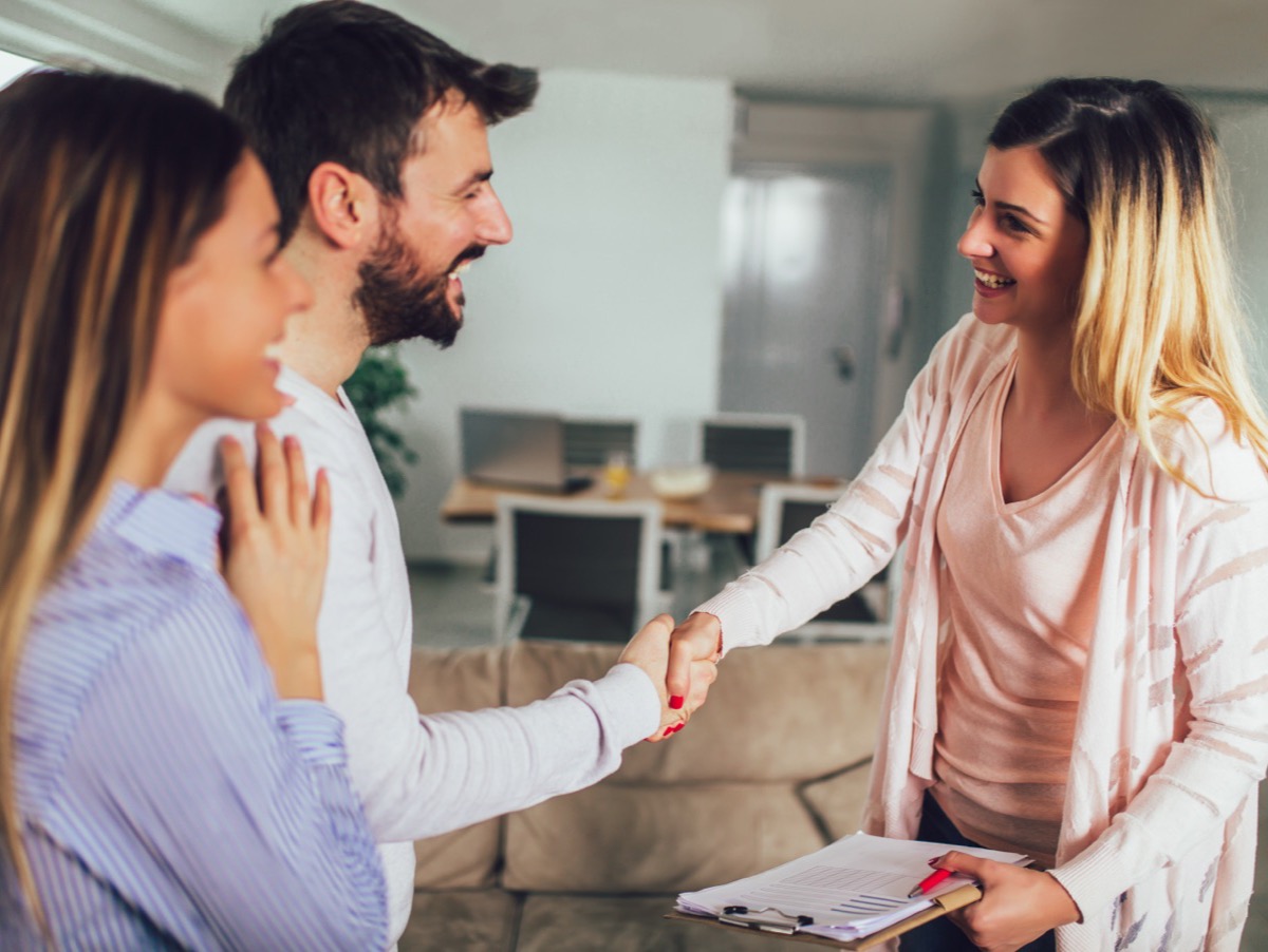 A couple greeting an agent inside a home they are viewing